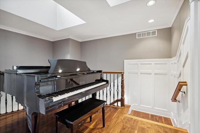 miscellaneous room featuring ornamental molding, a skylight, and hardwood / wood-style flooring