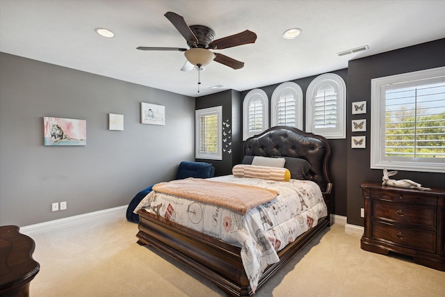 carpeted bedroom featuring multiple windows and ceiling fan