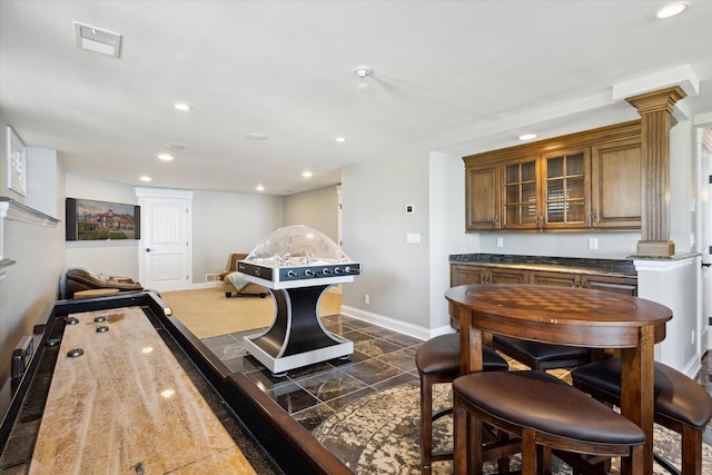 rec room with ornate columns and dark tile floors