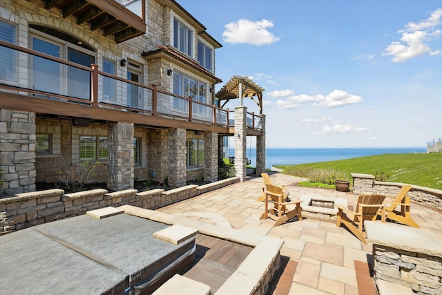 view of patio featuring a water view and a balcony