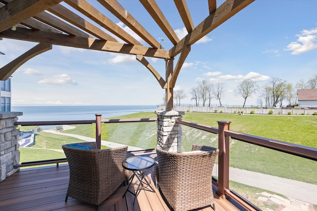 wooden deck featuring a yard, a water view, and a pergola