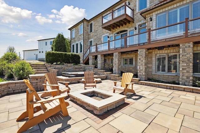 view of patio featuring a fire pit and a balcony