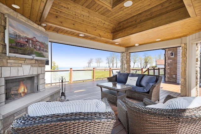 exterior space with wood-type flooring, plenty of natural light, an outdoor stone fireplace, and wood ceiling