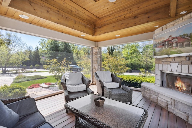 wooden terrace with an outdoor living space with a fireplace