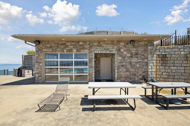 back of house with a water view and a patio area