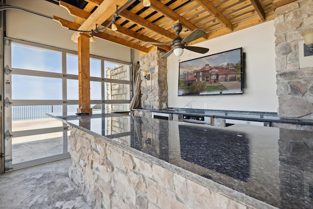 interior space featuring beamed ceiling, ceiling fan, light tile floors, wood ceiling, and dark stone countertops