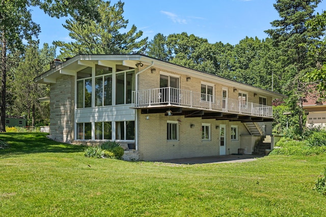 back of house featuring a wooden deck, a yard, a sunroom, and a patio