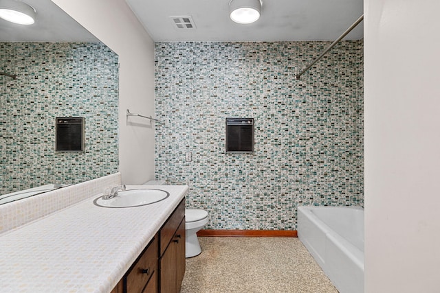 full bathroom with tiled shower / bath, vanity, and toilet