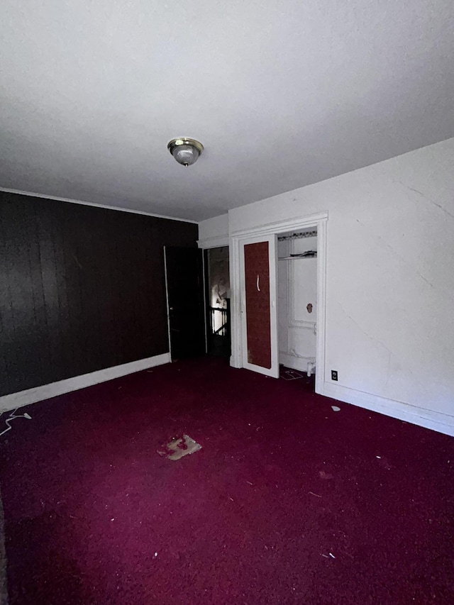 unfurnished bedroom featuring a closet and dark colored carpet