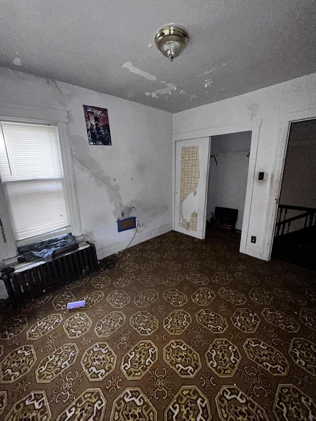 unfurnished bedroom with a closet and a textured ceiling