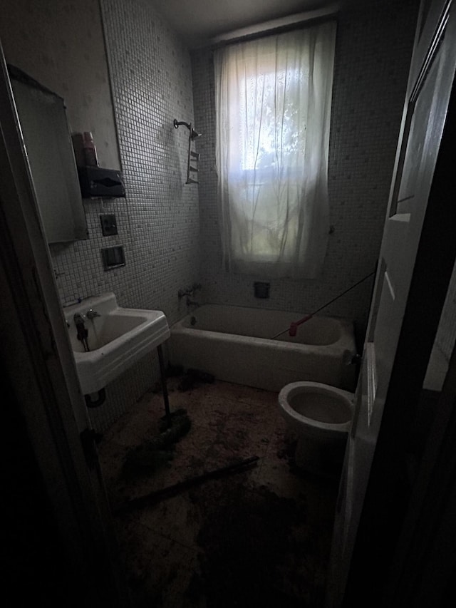 bathroom featuring sink, a washtub, tile walls, and toilet