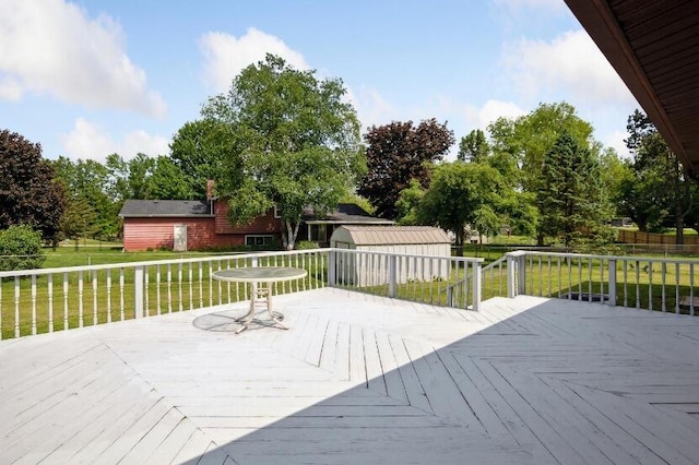 wooden terrace featuring a yard and an outdoor structure