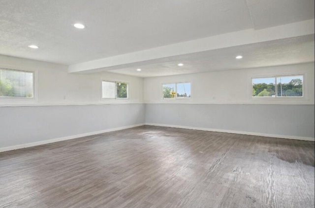 unfurnished room with dark hardwood / wood-style floors and beam ceiling