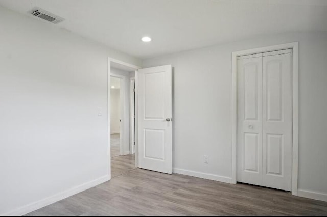 unfurnished bedroom featuring hardwood / wood-style floors and a closet