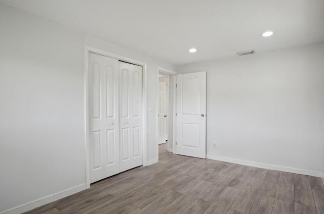 unfurnished bedroom with a closet and hardwood / wood-style floors