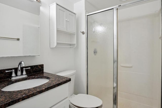 bathroom with walk in shower, vanity, and toilet