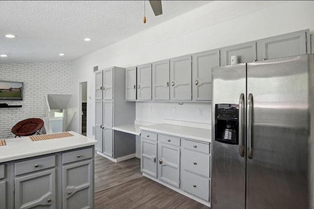 kitchen featuring a textured ceiling, gray cabinets, dark hardwood / wood-style flooring, and stainless steel fridge