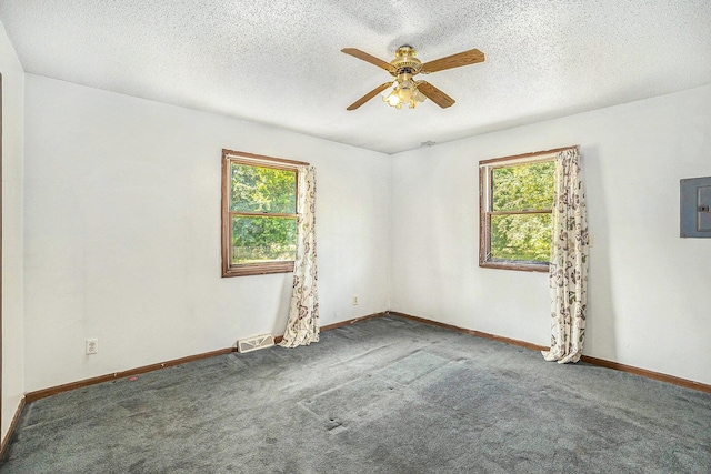 empty room with carpet, a textured ceiling, electric panel, and ceiling fan