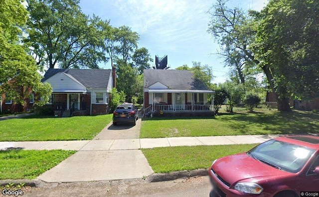 bungalow-style home featuring covered porch and a front lawn