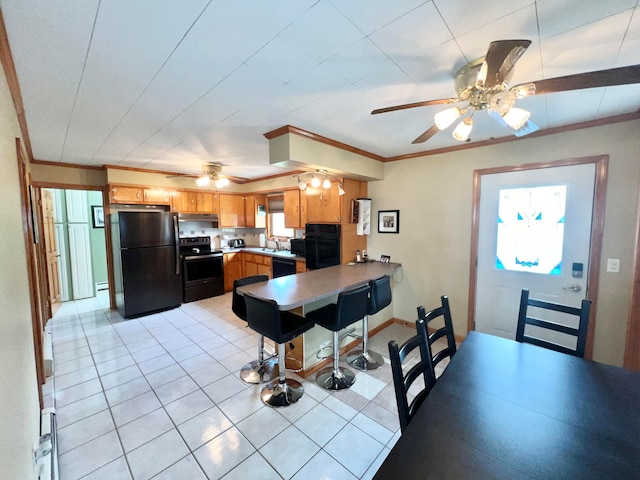 dining space with crown molding, sink, ceiling fan, and light tile floors