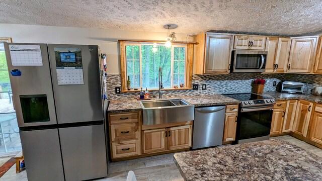 kitchen featuring backsplash, a textured ceiling, sink, and stainless steel appliances