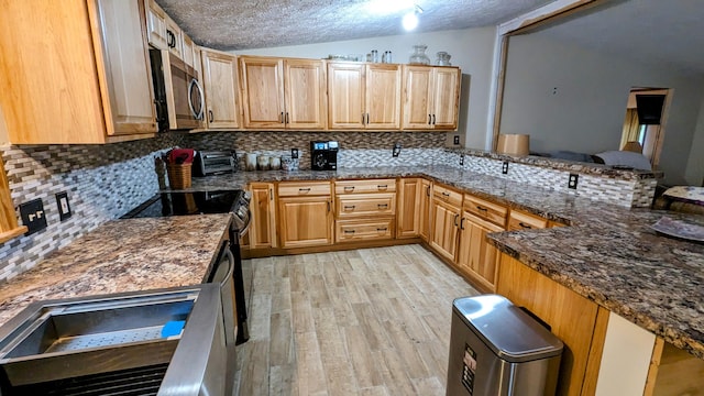 kitchen with lofted ceiling, tasteful backsplash, and a textured ceiling