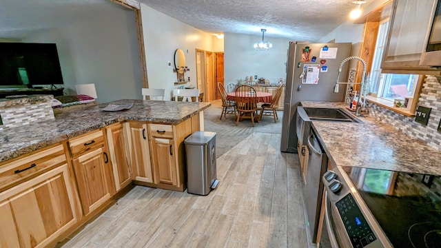 kitchen featuring backsplash, stove, stainless steel fridge, and a textured ceiling