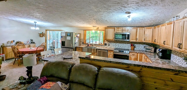 kitchen with hanging light fixtures, backsplash, stainless steel appliances, sink, and a textured ceiling