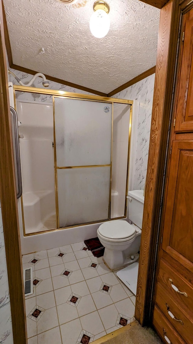 bathroom with an enclosed shower, toilet, tile flooring, and a textured ceiling