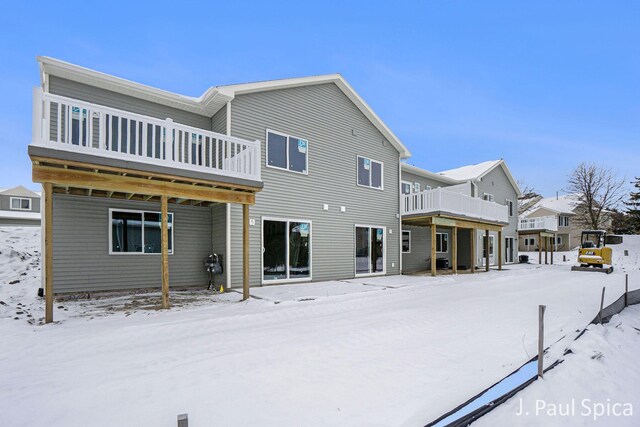 view of snow covered back of property