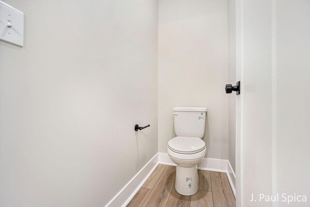 bathroom featuring wood-type flooring and toilet