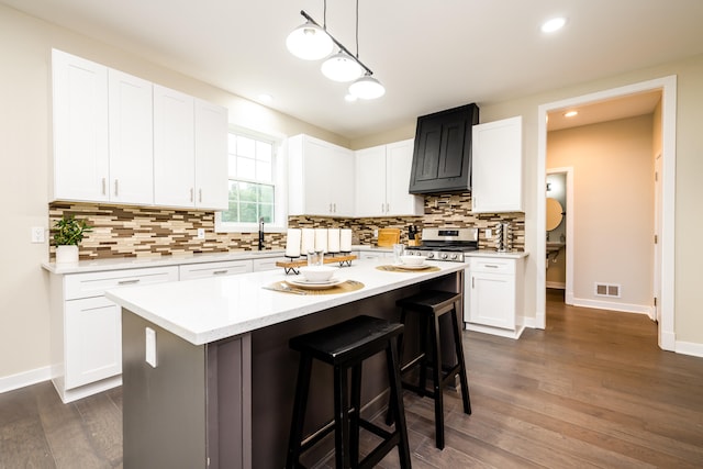 kitchen with decorative light fixtures, dark hardwood / wood-style flooring, backsplash, and a center island