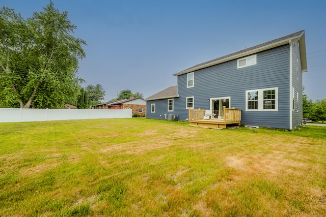 back of property featuring a lawn and a wooden deck