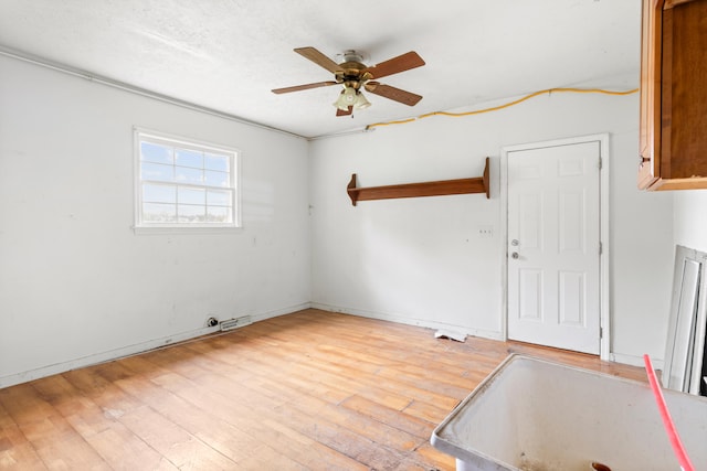 empty room with ceiling fan and light hardwood / wood-style flooring