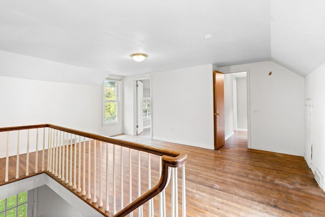 hallway with vaulted ceiling and hardwood / wood-style floors