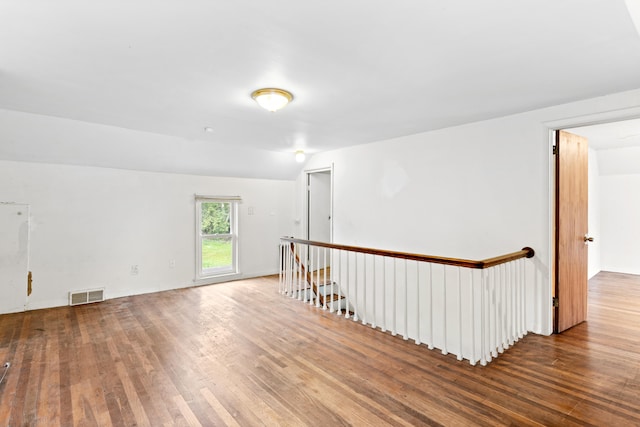 empty room with lofted ceiling and hardwood / wood-style flooring