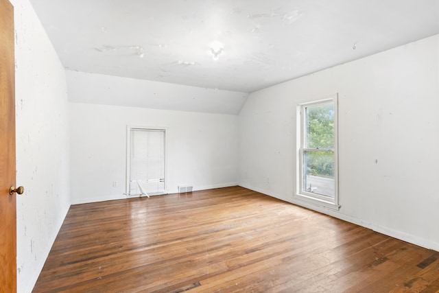 spare room with vaulted ceiling and wood-type flooring