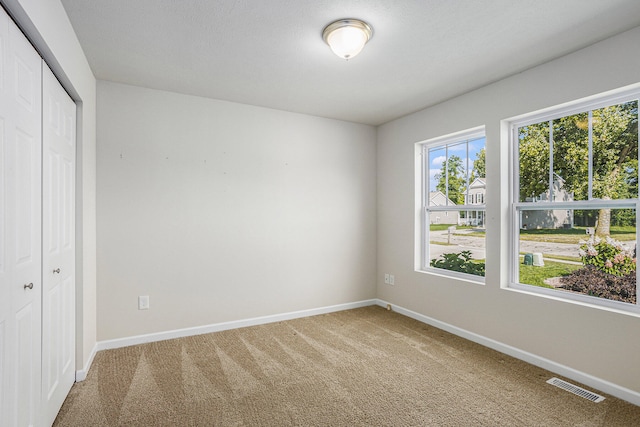 unfurnished bedroom featuring a textured ceiling, a closet, and carpet floors