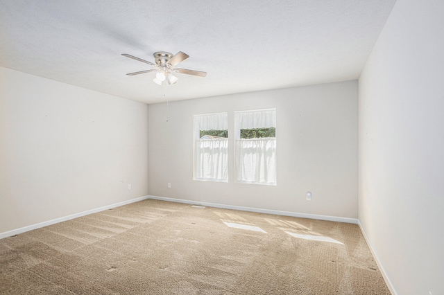 carpeted spare room featuring ceiling fan and a textured ceiling