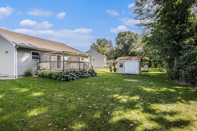 view of yard featuring a wooden deck and a storage unit