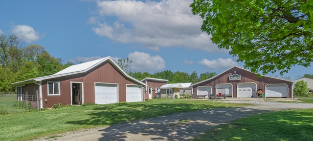 view of front facade with a front lawn, a garage, and an outdoor structure