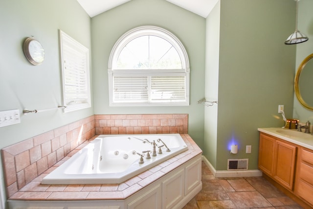 bathroom with tile flooring, vanity, and lofted ceiling