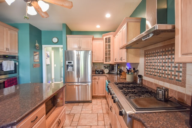 kitchen with appliances with stainless steel finishes, wall chimney exhaust hood, tasteful backsplash, ceiling fan, and light tile floors