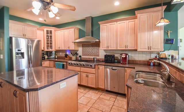 kitchen featuring decorative light fixtures, wall chimney range hood, a kitchen island, tasteful backsplash, and appliances with stainless steel finishes