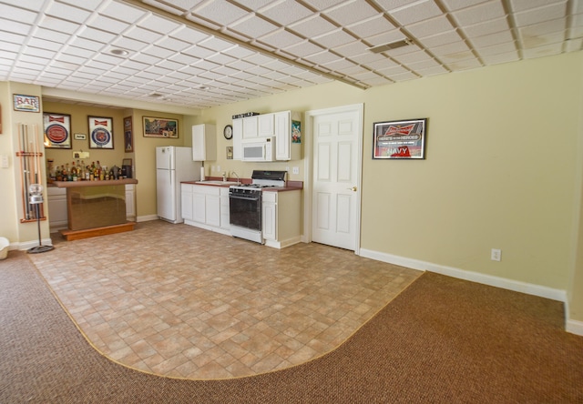 interior space featuring tile floors, sink, white cabinets, and white appliances