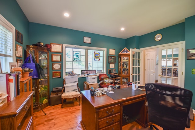 office area with light hardwood / wood-style floors and french doors