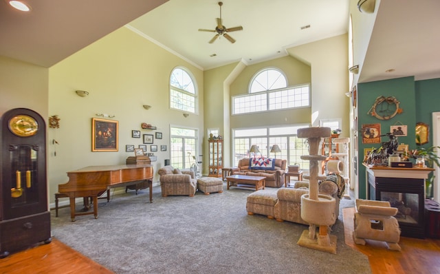 living room featuring high vaulted ceiling, a multi sided fireplace, wood-type flooring, and ceiling fan