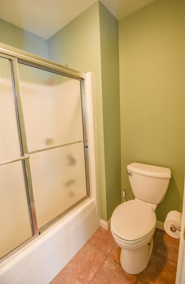 bathroom featuring tile flooring, toilet, and enclosed tub / shower combo