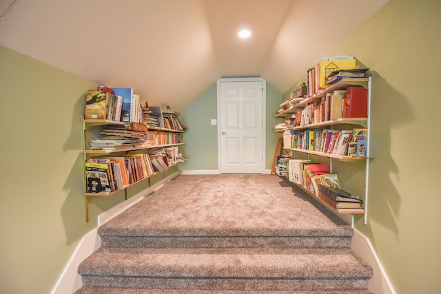 stairway featuring carpet floors and lofted ceiling