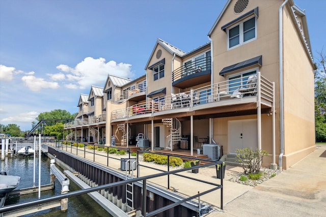 view of dock with a water view and central AC unit